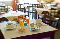 a table with breakfast foods and drinks on it at Hotel Atlantique in Mimizan-Plage