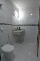a white bathroom with a toilet and a sink at Skala Traveling Hotel in Cuiabá