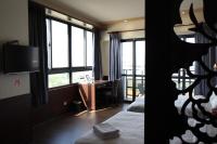 a hotel room with a bed and a desk and window at Lu Fang View in Donggang
