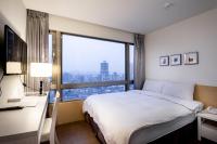 a hotel room with a bed and a large window at Wemeet Hotel Taipei in Taipei