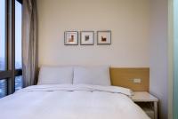 a bedroom with a white bed and three pictures on the wall at Wemeet Hotel Taipei in Taipei