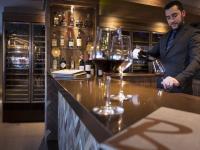 a man pouring a glass of wine at a bar at Le Taos in Tignes