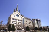 a large white building with a clock tower on it at International Hotel Ube in Ube