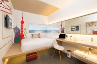 Un dormitorio con una cama y un escritorio con una computadora portátil. en Yaas Hotel Dakar Almadies, en Dakar