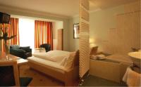 - une chambre avec un lit et une baignoire dans l&#39;établissement Hotel Alpina nature-wellness, à Wenns