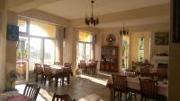 a dining room with tables and chairs and a clock at Cenacle B &amp; B in Chenggong