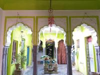 a hallway of a building with green and yellow walls at Shree Savitri Palace in Pushkar