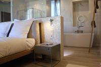 a bedroom with a bed and a tub and a sink at Les Suites Massena in Nice