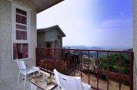 a balcony with two chairs and a view of the mountains at Sunny Room in Jiufen