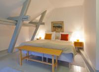 Un dormitorio con una cama y una mesa de madera. en Ahlströmin Ruukki Noormarkku, en Pori
