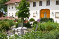 a garden with a table and chairs in front of a house at Bauernhofpension Herzog zu Laah in Linz