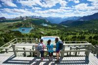 a group of children standing on top of a viewing platform at Sunshine Mountain Lodge in Banff