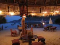 a restaurant on the beach with tables and chairs at Malibu Beach Bungalows in Chaloklum