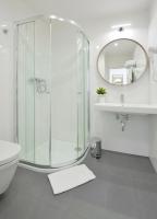 a bathroom with a shower and a toilet and a mirror at Hotel Garden Court in Prague