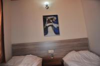 a bedroom with two beds and a picture on the wall at SunAnatolia Otel in Antalya