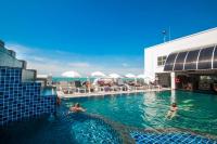 Una piscina en un hotel con gente en el agua. en Flipper House Hotel - SHA Extra Plus, en Pattaya central
