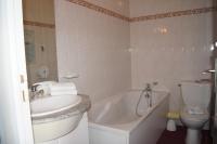 a bathroom with a sink and a tub and a toilet at Aux Trois Jean in Le Crotoy