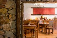 a kitchen with wooden tables and a stone wall at Lares De Chacras in Chacras de Coria