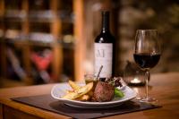 a plate of food and a glass of wine at Lares De Chacras in Chacras de Coria