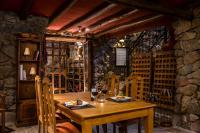 a wooden table in a room with a stone wall at Lares De Chacras in Chacras de Coria