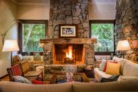 a large living room with a stone fireplace at Lares De Chacras in Chacras de Coria