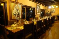 Una mesa larga en un restaurante con una pintura de un caballo en la pared. en Hacienda Leito, en Patate