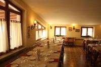 uma sala de jantar com uma mesa longa com pratos em Hotel Piccola Mantova em Bosco Chiesanuova