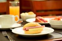 uma sandes num prato numa mesa com uma chávena de café em Easy Hotel Cachoeiro de Itapemirim by Atlantica em Cachoeiro de Itapemirim