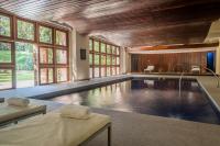 una piscina en una casa con ventanas en Hotel del Bosque, en Pinamar