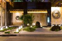 a building with a courtyard with plants in front of it at Bandara Suites Silom, Bangkok in Bangkok