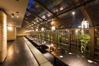 a restaurant with long tables in a room with windows at Bandara Suites Silom, Bangkok in Bangkok