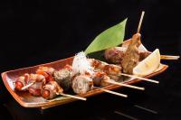 a plate of food with shrimp and meat on skewers at Bandara Suites Silom, Bangkok in Bangkok