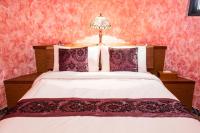 a bedroom with a large bed with red walls at Zum Adler Castle B&amp;B in Jiaoxi