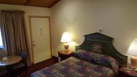 a hotel room with a bed and a table and a lamp at Atlantic Motel in Point Pleasant Beach