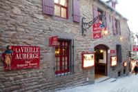 a brick building with signs on the side of it at La Vieille Auberge in Le Mont Saint Michel