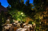 a restaurant with white tables and chairs and a tree at La Maison d&#39;Uzès Relais &amp; Châteaux in Uzès