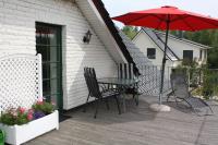 a patio with a table and chairs and an umbrella at Pension Landhaus Teichgraf in Wolgast