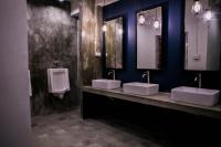 a bathroom with three sinks and two urinals and a urinal at Silom Space Hostel in Bangkok
