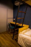 a bedroom with a bunk bed with a desk and a chair at Silom Space Hostel in Bangkok