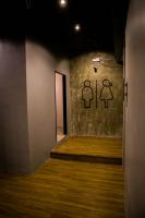 a hallway with a wall with two bathroom signs on it at Silom Space Hostel in Bangkok