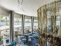 a lobby with tables and chairs and a building at Chatrium Hotel Riverside Bangkok in Bangkok