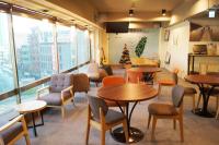 a restaurant with tables and chairs and a christmas tree at Trip GG Hostel in Kaohsiung