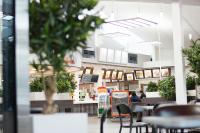a restaurant with tables and chairs and people in the background at Autokeidas Forssa Motelli in Forssa