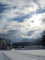 a snow covered road with the sun in the sky at Ferienwohnung Familie Wieser in Altenmarkt im Pongau