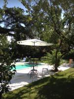 a white umbrella and chair next to a swimming pool at Le Moulin du Carla in Lavaur