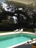 a swimming pool with two chairs and a tree at Le Moulin du Carla in Lavaur
