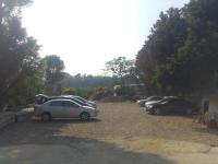 a group of cars parked in a gravel parking lot at Song Youf Hostel in Zhongpu