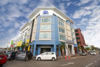 a blue and white building with cars parked in a parking lot at Pantai Regal Hotel in Kuantan