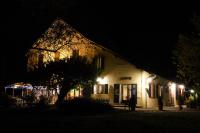 a building at night with a tree in front of it at Glamping at Camping La Source in Saint-Pierre-dʼArgençon