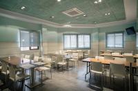 Un restaurante con mesas y sillas en una sala. en Hotel Rostits, en Castellón de la Plana